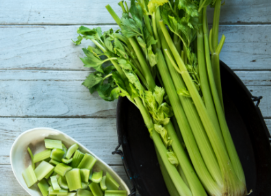 Celery Stalks on a plate with cut up celery in a bowl, to the right